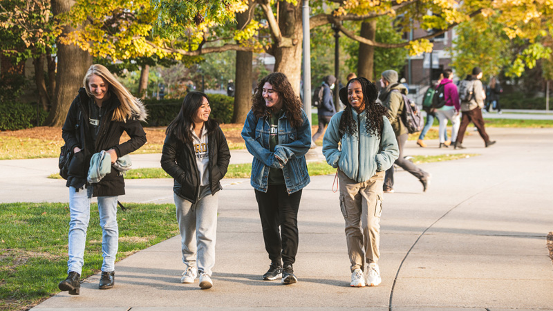 A group of young women walking together and laughing.